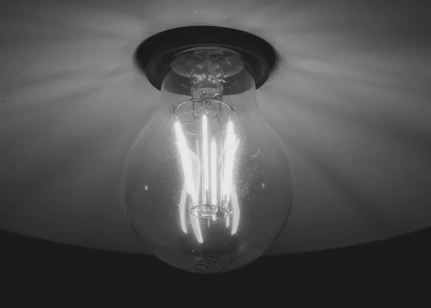 Filament bulb lit against a dark ceiling