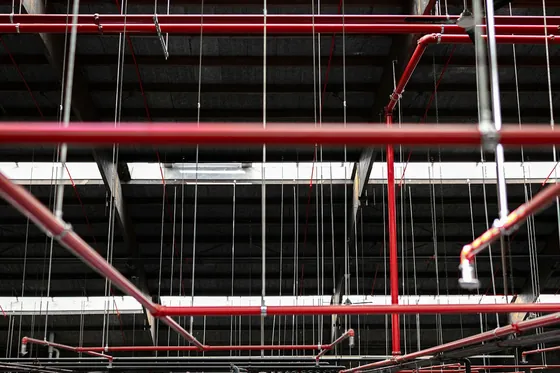 Red fire sprinkler pipework under a ceiling