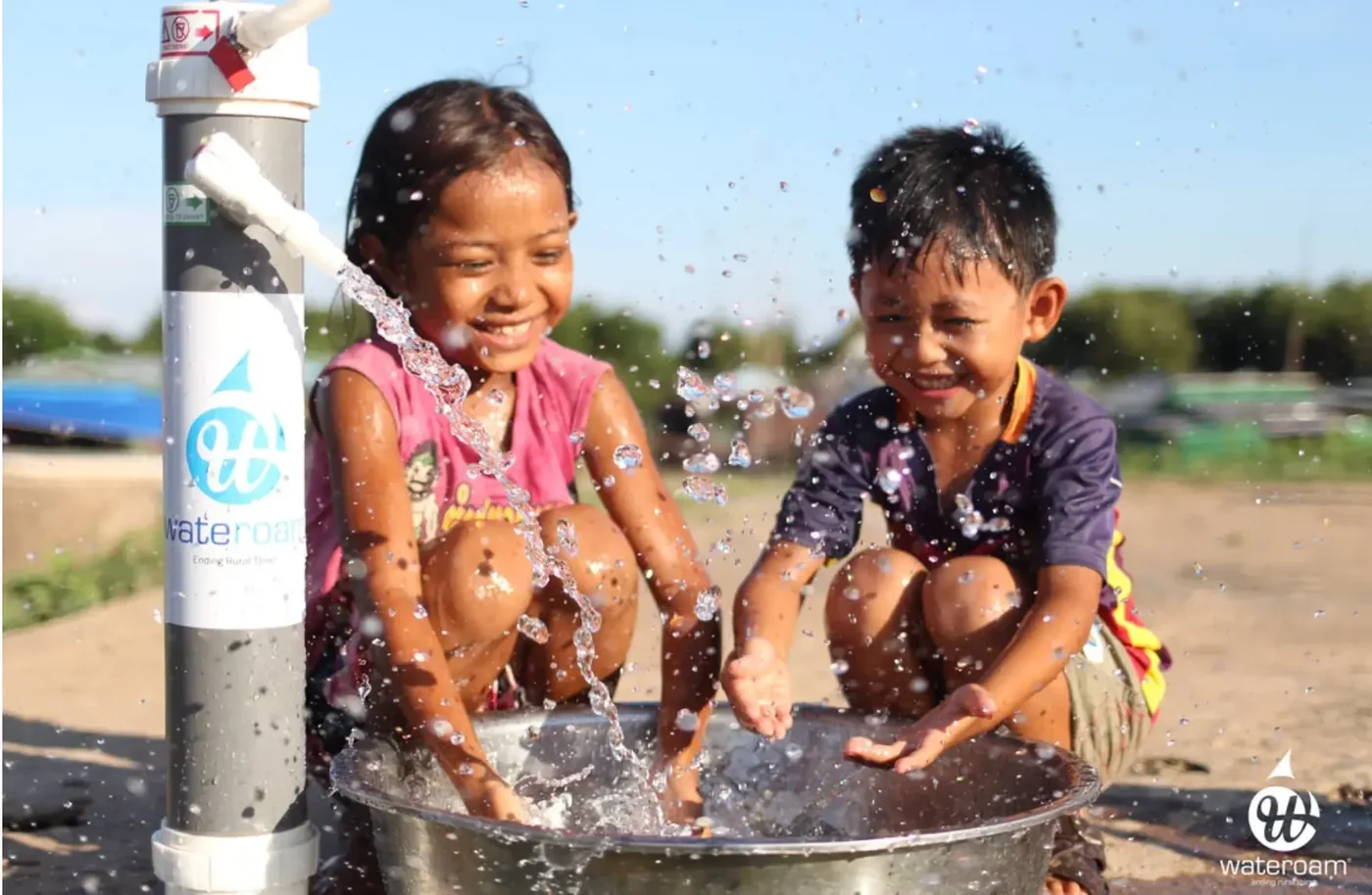 Children drinking from a portable purification unit in a rural village